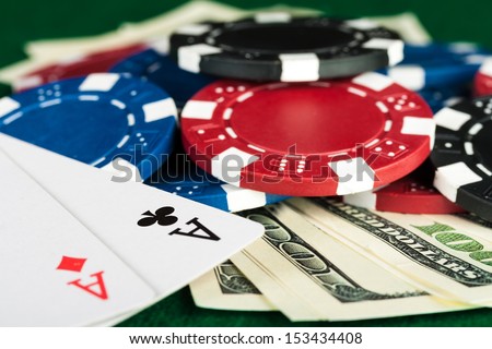 Group of chips, money and poker cards on the green cloth.