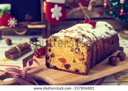 Christmas Cake and Christmas Decorations. Stollen with Marzipan, Berries and Nuts. Photo  in Vintage Tone Style.