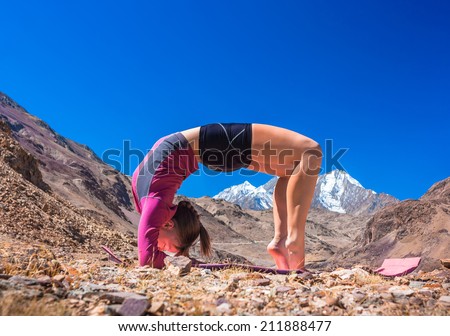 Young woman doing yoga in mountain landscape