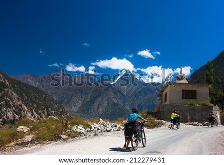 Three cyclist going on mountains road. Himalayas, Jammu and Kashmir State, North India