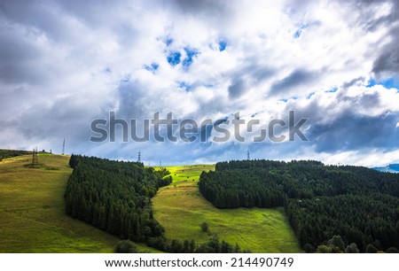 Sunny cloudy landscape with mountains, sky and trees