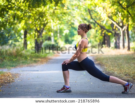 Fitness woman doing streching during outdoor cross training workout. Beautiful young and fitness sport model training outside