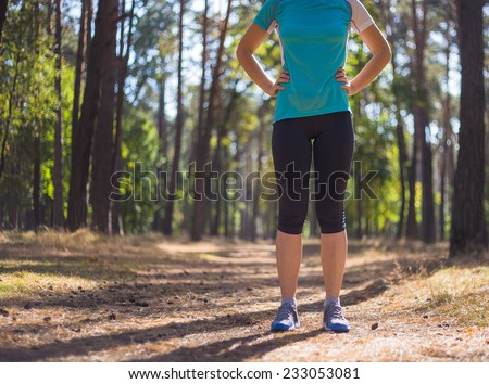 Runner woman training on forest road in beautiful nature. Caucasian female sport fitness model jogging training for marathon during outdoor workout.