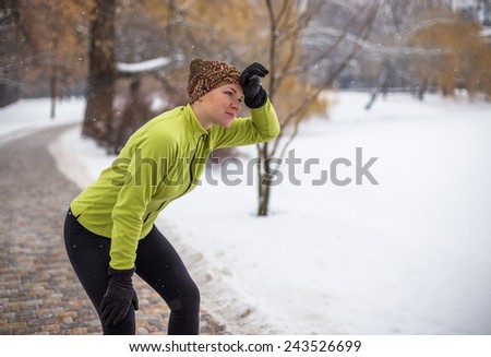 Runner woman in city park outdoor. Caucasian female sport fitness model jogging training for marathon during winter outdoor workout.