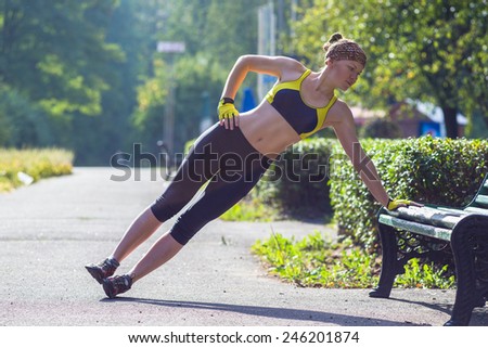 Fitness woman doing push-ups during outdoor cross training workout. Beautiful young and fit fitness sport model training outside.