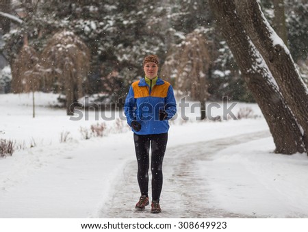 Young sport woman jogging during winter training outside in cold snow weather