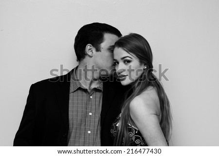 Young Man whispering at Young Girl's Ear