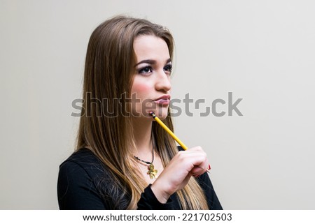 Young White girl Thinking while holding pencil