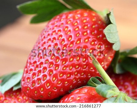 fresh red strawberry texture closeup with green leaf good for vitamins and health