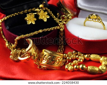asian tradition wedding set of shiny gold ring earring necklace bracelet in jewellery box on red background