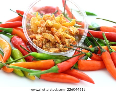 dried shrimps in a plastic container with red hot chili for cooking closeup on white background