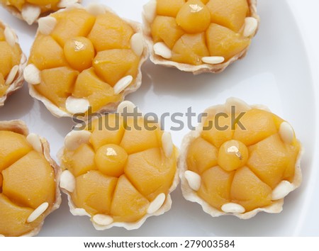 Thai sweet dessert in shape like golden crown with real gold tip on white dish