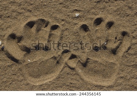 hands print on the sand beach texture