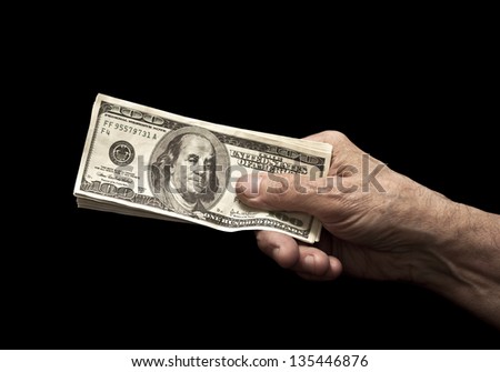 Dollars in old hand isolated on black