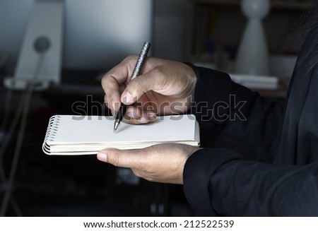 Businesswoman takes notes in office