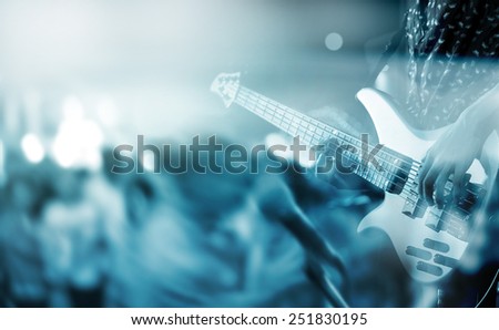 abstract motion blur guitarist on stage and people dance in floor, blue tone and blur concept