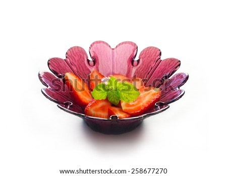 strawberry slice with mint in purple flower shape bowl on white background, soft focus