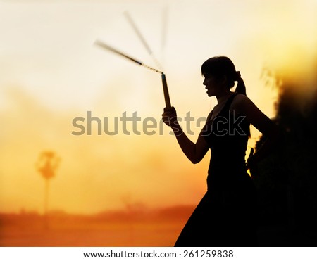 martial arts, women and nunchaku in hands silhouette in sunset