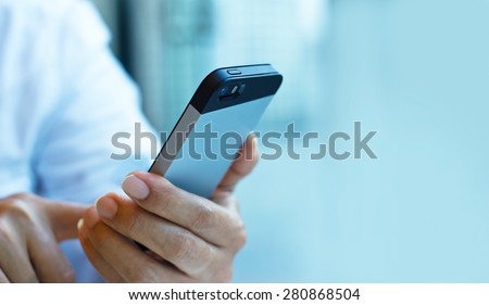 Close up of a man using mobile smart phone on pastel color tone, soft focus