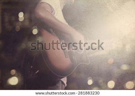 Guitarist on stage grunge background, vintage and retro color tone style, soft and blur concept