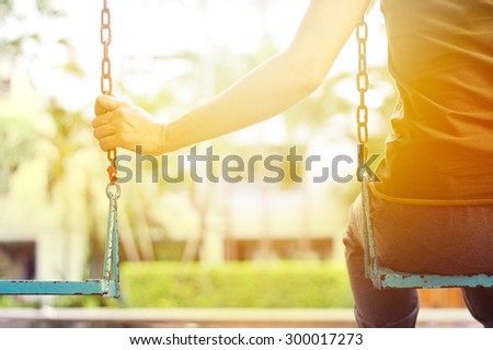 Lonely woman missing her boyfriend while swinging in the park villa in the morning