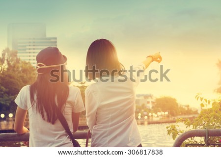 Two women take a sight seeing near the river in the nature sky background, Vintage color tone