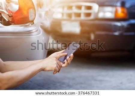 Man using smartphone at roadside after traffic accident