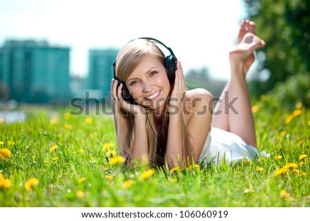 Beautiful smiling woman Woman listening to music on headphones outdoors