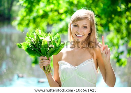 Young beautiful artistic woman with flowers outdoors