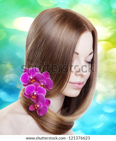 Beautiful woman with with orchids in her gorgeous hair