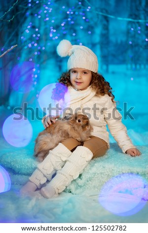 Little cute winter girl with rabbit