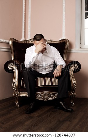 Man in a luxurious armchair in the rich interior