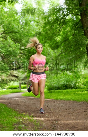 Young woman playing sports, running in the park