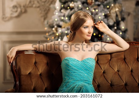 Luxury blonde in interior New Year. Young beautiful trendy girl celebrating Christmas. The friendly woman
