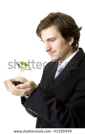 Image of a businessman holding a young plant