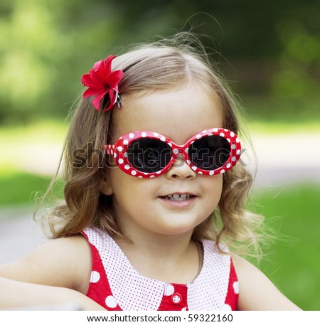 The image of a little girl in fashionable sunglasses