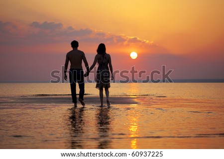 people holding hands in the sunset. people in love at sunset