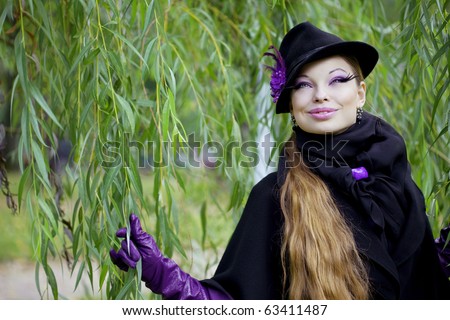 The image of a beautiful girl in a purple dress in the autumn park
