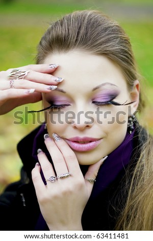 The image of a beautiful girl in a purple dress in the autumn park