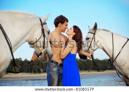 Image of a man and a woman in love with the sea with horses