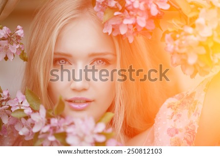 Young spring fashion woman  in spring garden. Springtime. Trendy girl at sunset in spring landscape background. Allergic to pollen of flowers. Spring allergy