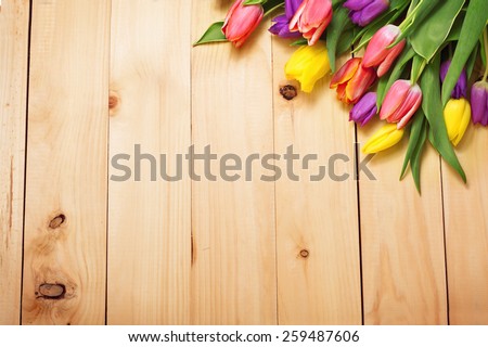 Spring Flowers bunch at wood floor texture. Beautiful Tulips bouquet gift. Easter or Mother\'s Day  background. Springtime or summertime. Invitation card design with space for your text