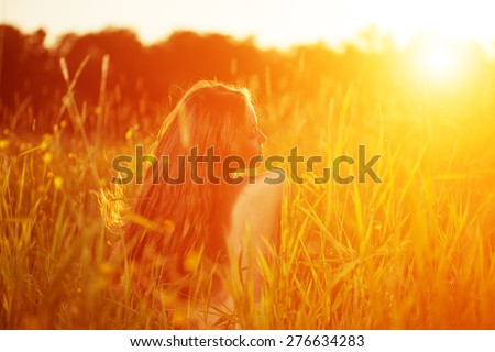 Young hipster model woman Casual Girl in field in Sunset in spring, summer landscape background Springtime Summertime. Allergic to pollen of flowers Allergy Backlit Sun Light Autumn Glow Sun Sunshine