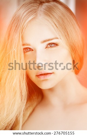 Woman face close up. A pretty young blond trendy. Girl with a beauty face. Beautiful female face with luxury make-up