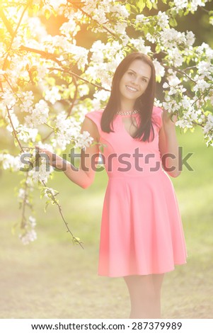 Young spring fashion woman in spring garden. Springtime. Trendy girl at sunset in spring landscape background. Allergic to pollen of flowers. Spring allergy
