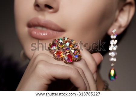 Diamond. Brilliant. Antique old vintage earrings and ring. Jewelry on her finger at the girl close-up on a