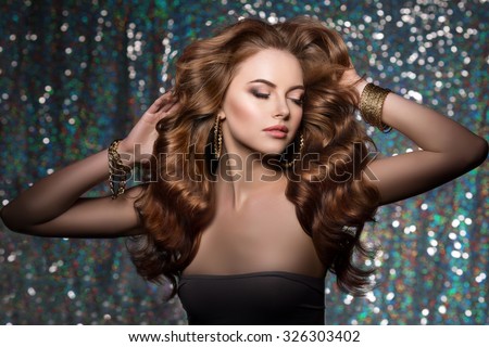 Woman club lights party background Dancing girl Long hair. Waves Curls Updo Hairstyle. Hair Salon Fashion model with shiny  healthy hair with luxurious haircut. Hair volume Jewelry Bracelets Earrings