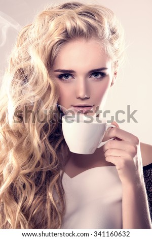 Model with coffee cup, mug in coffee shop. Fashion Woman, tea party time. Blonde girl, tea set