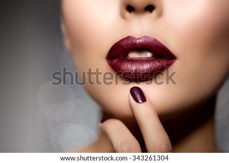 Red woman lips close up. Beautiful model girl with lipstick, manicure with nail polish Products Treatment