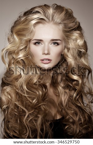 Model with blonde long hair. Waves Curls Hairstyle. Hair Salon. Updo. Fashion model with shiny hair. Woman with healthy hair girl with luxurious haircut. Hair loss Girl with hair volume.